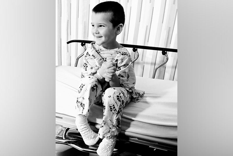 微笑的男孩坐在医院的病床上
